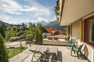 een patio met stoelen en een tafel op een balkon bij Hotel La Perla in Andalo