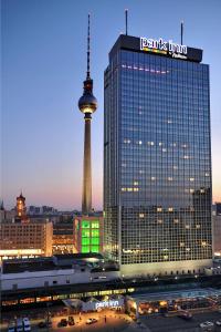 ein großes Gebäude mit einem Turm im Hintergrund in der Unterkunft Park Inn by Radisson Berlin Alexanderplatz in Berlin