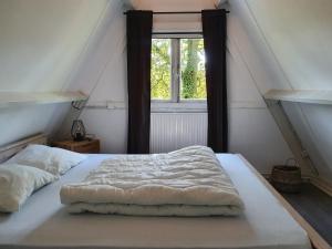 Cama en un ático con ventana en Gezellige bungalow met zwembad op het park, en Durbuy