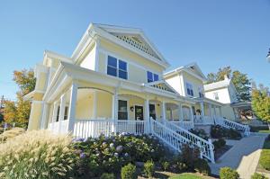 una gran casa blanca con flores en el patio delantero en Grant Street Inn - Bloomington, en Bloomington