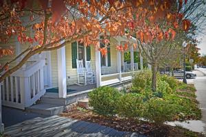 Una casa amarilla con un árbol delante. en Grant Street Inn - Bloomington, en Bloomington