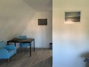 a dining room with a table and blue chairs at Bed en Boomgaard in Giethoorn