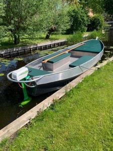 a boat is docked at a dock in the water at Bed en Boomgaard in Giethoorn