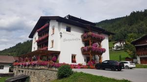 un edificio con dei fiori sul lato di Pension Burgschroffen a Fendels