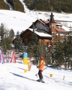 osoba na nartach w śniegu przed domkiem w obiekcie Piz Alpin B&B w mieście Colfosco