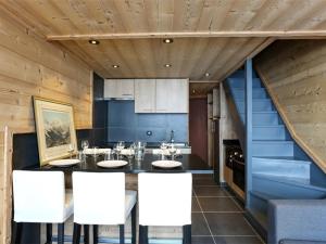 eine Küche mit einem Esstisch und weißen Stühlen in der Unterkunft Duplex rénové à Val Thorens, 3 chambres, 6 pers, proche pistes et commerces - FR-1-637-49 in Val Thorens