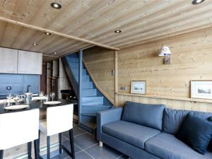 ein Wohnzimmer mit einem blauen Sofa und einer Treppe in der Unterkunft Duplex rénové à Val Thorens, 3 chambres, 6 pers, proche pistes et commerces - FR-1-637-49 in Val Thorens