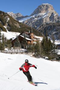 Człowiek zjeżdża na nartach z góry pokrytej śniegiem w obiekcie Piz Alpin B&B w mieście Colfosco