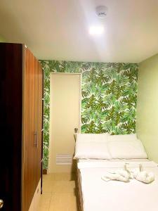 um quarto com uma cama com papel de parede tropical em Mahayahay Lodge and Restaurant em Mactan