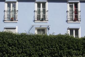 um edifício branco com varandas e uma sebe em The Blue House em Erlangen