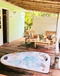 een jacuzzi op de veranda van een huis bij Villa Gaïa - Bungalow Ti-Zen et son jacuzzi niché dans un jardin tropical, séjour en amoureux in Le Diamant