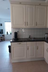 a kitchen with white cabinets and a sink at De Poldersteeg 