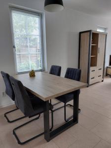 a wooden table and chairs in a room with a window at De Poldersteeg 