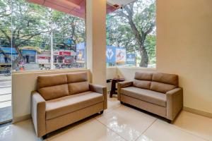 a waiting room with two chairs and a window at Itsy Hotels NRM Residency in Mysore