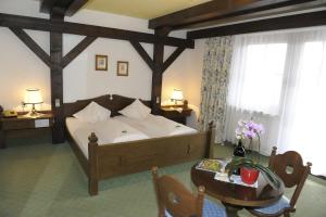 Un dormitorio con una cama grande y una mesa con una mesa. en Hotel Stegmühlhof, en Mauterndorf