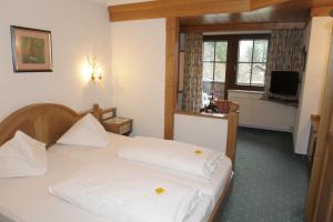 1 dormitorio con cama blanca y ventana en Hotel Stegmühlhof, en Mauterndorf