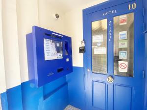 eine blaue Tür mit einem Ticketautomaten in einem Zimmer in der Unterkunft Hotel Aviatic in Paris