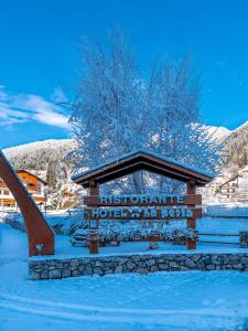 un cartello per un hotel storico nella neve di Hotel La Perla a Ravascletto