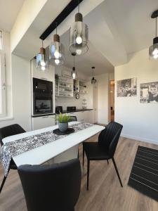 ein Esszimmer mit einem weißen Tisch und Stühlen in der Unterkunft Sky View - Luxury Apartament - Sanador Victoriei in Bukarest