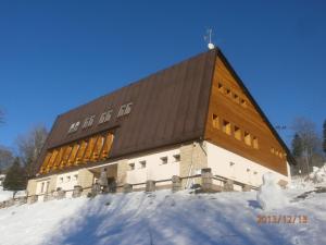 ストラージュネーにあるHotel Vltavaの雪の大きな木造の建物