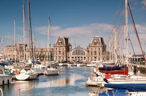 un grupo de barcos atracados en un puerto con edificios en Ostend Hotel, en Ostende