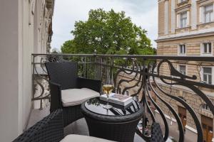 un balcón con una mesa y una copa de vino en Ribas Duke Boutique Hotel, en Odessa