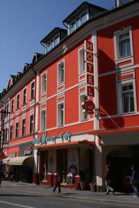 um edifício vermelho com um sinal para um clube de caçadores de comida em Altstadt Hotel Mosser em Villach