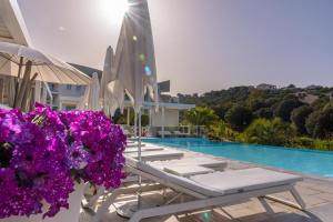 un grupo de tumbonas y flores junto a una piscina en Residence de Tourisme Ajaccio Amirauté, en Ajaccio