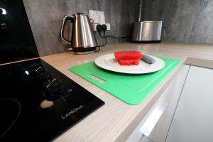 une assiette de fruits sur un comptoir avec un couteau dans l'établissement Signature - Carnoustie House, à East Kilbride