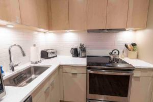 una cucina con lavandino e piano cottura forno superiore di Spacious 2 bed 2 bath Downtown OTR condo minutes walk to the Reds Bengals stadium & more! a Cincinnati