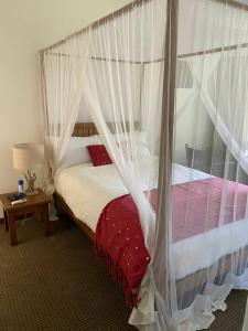 1 dormitorio con 1 cama con dosel en Burley House by Ulendo, en Lilongwe