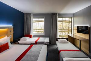 pokój hotelowy z dwoma łóżkami i telewizorem w obiekcie Holiday Inn Express Paris-Canal De La Villette, an IHG Hotel w Paryżu