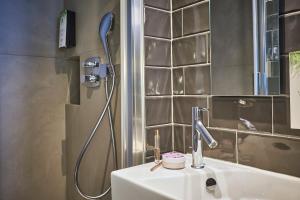 La salle de bains est pourvue d'un lavabo et d'une douche. dans l'établissement Hotel Campanile Paris-Bercy Village, à Paris