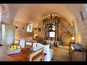 a living room with white furniture and a stone wall at Arapakis Historic Castle in Pirgos Dhirou