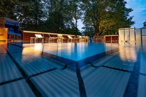 uma piscina com mesas e cadeiras em Thermenhotel Apollo em Bad Füssing