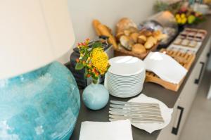 une table avec des assiettes et un vase bleu avec des fleurs dans l'établissement Suytes, à Heidelberg