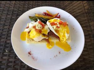 um prato branco com sanduíche de ovo e legumes em Bintang Bungalow em Nusa Penida