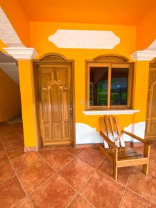 a room with a wooden door and a chair at El Mirador de Tansu in Lanquín