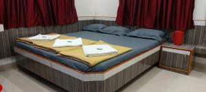 un letto con asciugamani bianchi sopra di Sai Raghunandan Guest House a Shirdi