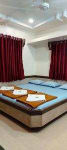 Posto letto in camera con tende rosse. di Sai Raghunandan Guest House a Shirdi