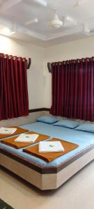 Posto letto in camera con tende rosse. di Sai Raghunandan Guest House a Shirdi