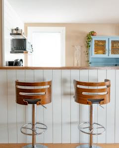 a kitchen with two bar stools in front of a counter at Sunroom on Maple in Picton