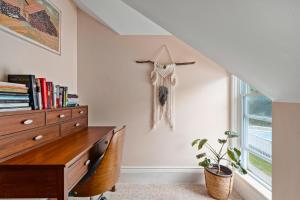 a bedroom with a desk and a dresser and a window at Sunroom on Maple in Picton