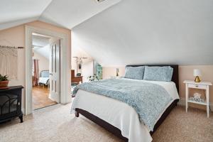 a bedroom with a large bed with blue pillows at Sunroom on Maple in Picton