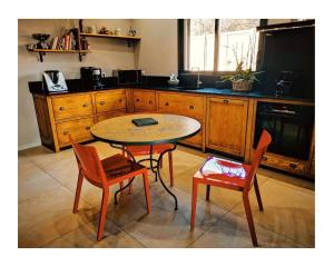 uma cozinha com uma mesa e duas cadeiras e uma mesa em Villa de charme à Ajaccio em Ajaccio