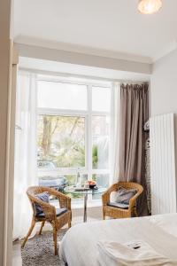 sypialnia z łóżkiem i krzesłami oraz oknem w obiekcie Sweet Suites Lytham w mieście Lytham St Annes