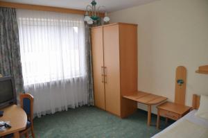 uma sala com um quarto com um armário e uma janela em Hotel Garni em Bad Schallerbach