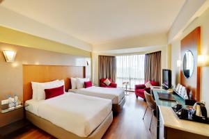 a hotel room with two beds and a television at The Golkonda Hotel in Hyderabad