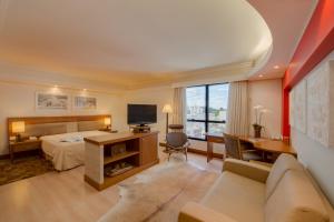 a bedroom with a bed and a desk with a television at Blue Tree Towers Caxias do Sul in Caxias do Sul