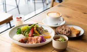 un tavolo con un piatto di cibo e una tazza di caffè di HOTEL RINGS KYOTO a Kyoto